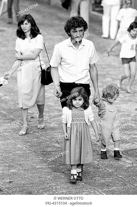 SPANIEN, PUERTO DE LA CRUZ, 15.04.1981, Eighties, black and white photo, people, family, parents take a walk with daughter and son, tourists, man with cigarette