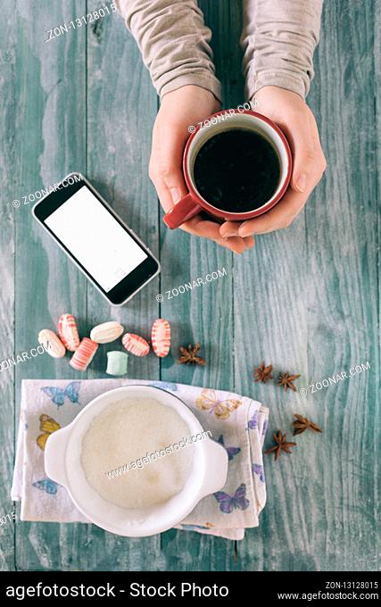 Smartphone and cup of strong coffee on wooden background. Cell phone with writing set with espresso