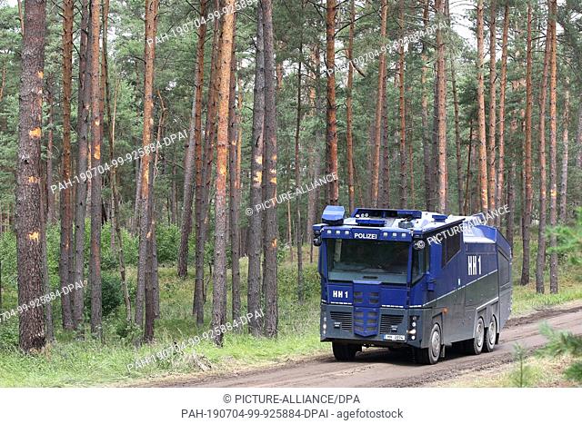 04 July 2019, Mecklenburg-Western Pomerania, Alt-Jagel: A water cannon drives on a forest path near the village of Trebs during the extensive forest fire