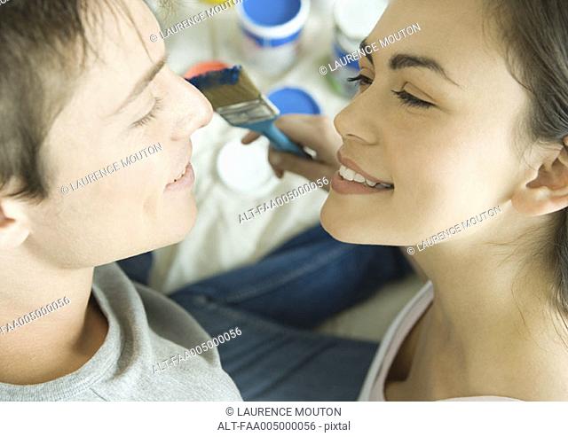 Couple face to face with painting materials in background