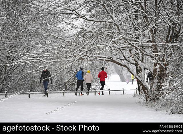 Weather picture / Winter in the English Garden in Muenchen - walkers and joggers cavort in the snow after the onset of winter in Munich on January 6th