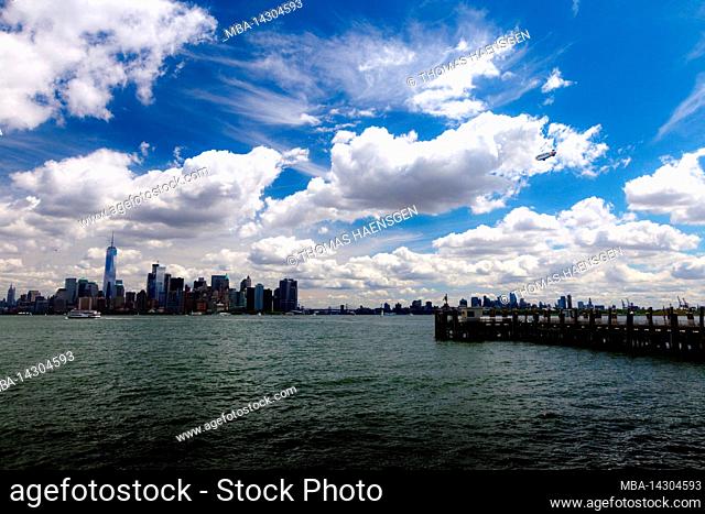 LIBERTY ISLAND, New York City, NY, USA, a dramatic sky and a zeppelin over New York City Skyline of New York City, Lower Manhattan and a dramatic sky with a...