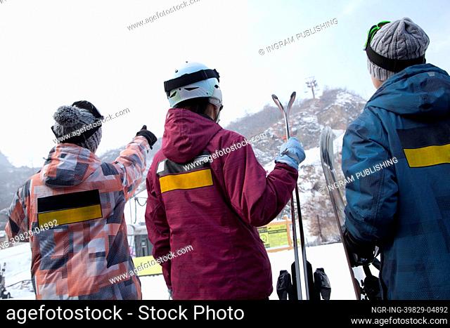 Group of People Pointing at Hill in Ski Resort