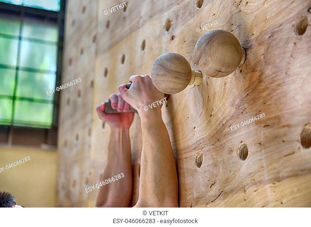Muscular Climber Man Climbing Up On Wooden Practice Wall In Gym? Close Up