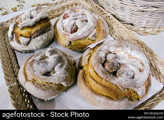 Horizontal photo of wicker tray with four folares, traditional Portuguese Easter cake or sweet bread