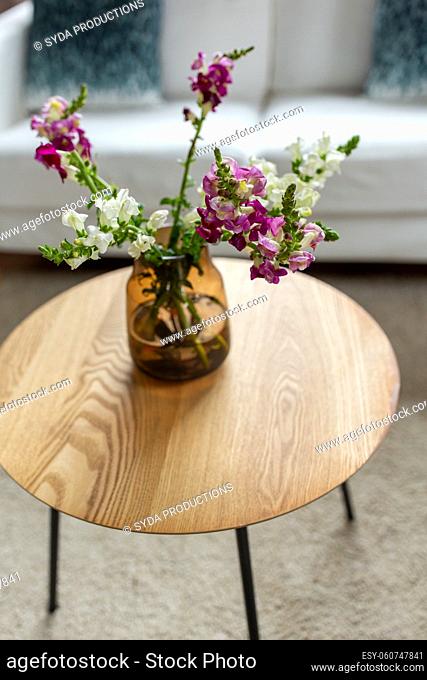flowers in vase on round coffee table at home