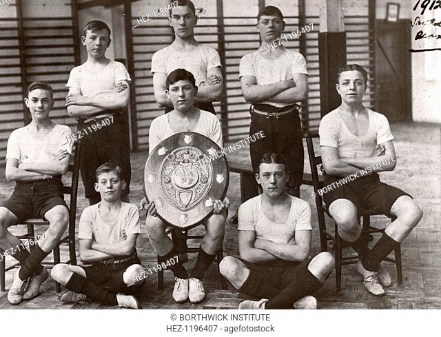 Boys gym team pose with trophy, York, Yorkshire, 1912. This group of boys from the Saw Mill won the interdepartmental gymnastic shield in 1912