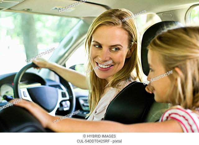 Mother and daughter talking in car