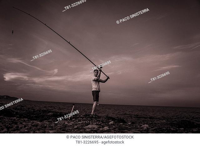 Fisherman throwing the fishing rod, Alcocebre, Castellon province, Valencian Community, Spain
