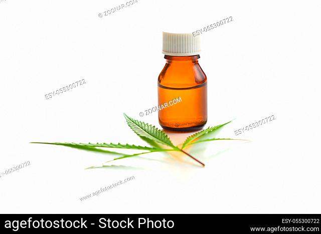 Marijuana cannabis leaf and cannabis oil extract in jar isolated on white background