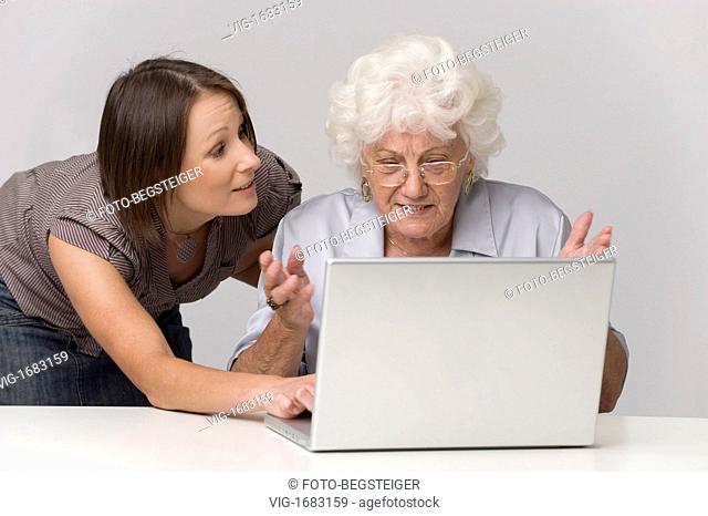 young woman helps older person using laptop - 14/09/2009