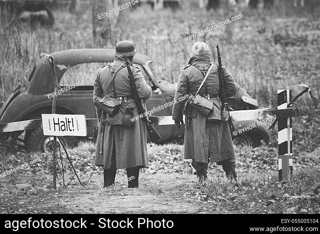 Two Re-enactors Dressed As German Infantry Wehrmacht soldier at World War II are on patrol in autumn field