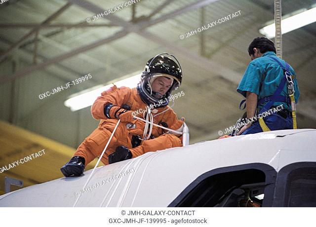 Astronaut James M. Kelly, STS-114 pilot, uses a device called a Sky genie to simulate rappelling from a troubled shuttle in a training session in the Space...