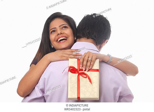 Rear view of a woman with a gift hugging