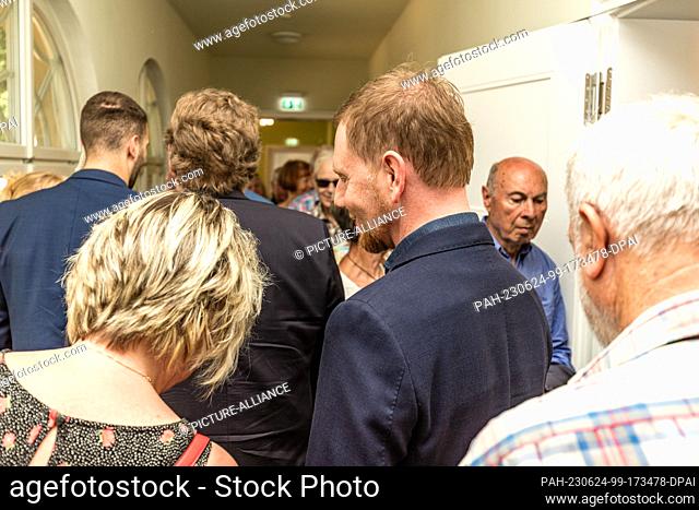24 June 2023, Saxony, Bad Muskau: Michael Kretschmer (CDU), Prime Minister of Saxony and Sebastian Hecht, visits an exhibition at Hermannsbad in Bad Muskau...