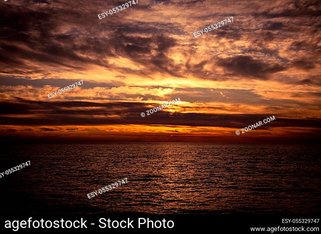 Dramatic sky with clouds at sunset over Adriatic sea near Peschici town on Gargano peninsula, Italy