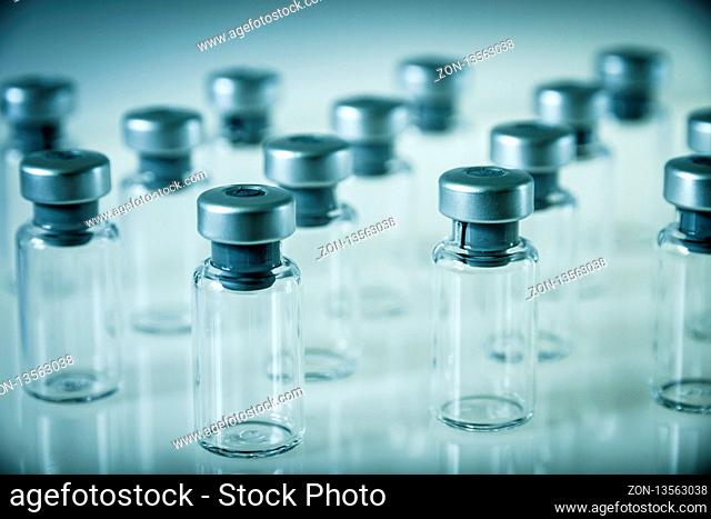 Group of vaccine glass bottles on grey background
