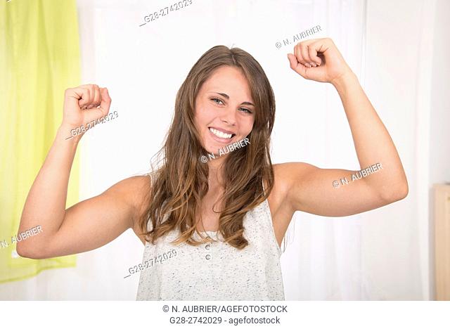 Young woman lifting hers arms to express her happiness