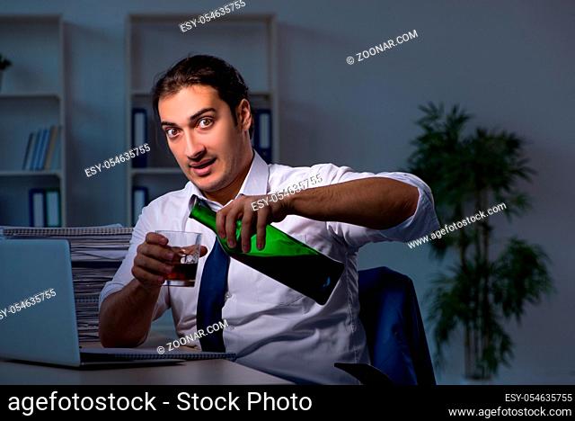 Alcohol addicted businessman working late