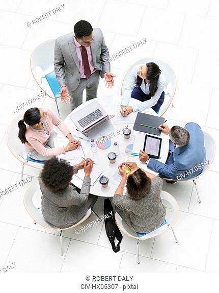 High angle view businessman leading meeting at round table