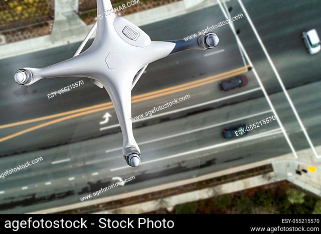 Unmanned Aircraft System Quadcopter Drone In The Air Over Roadway with Automobiles