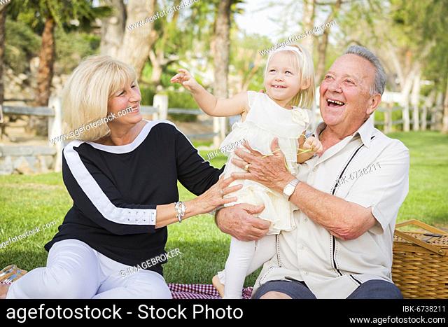 Affectionate granddaughter and grandparents playing outside at the park