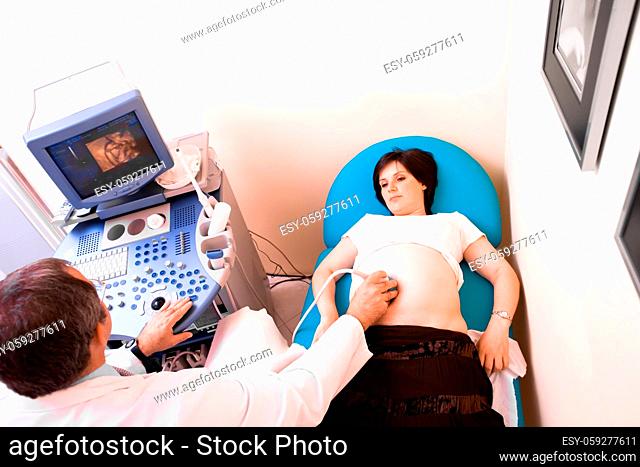 Obstetrician examining pregnant belly by 4D ultrasonic scan