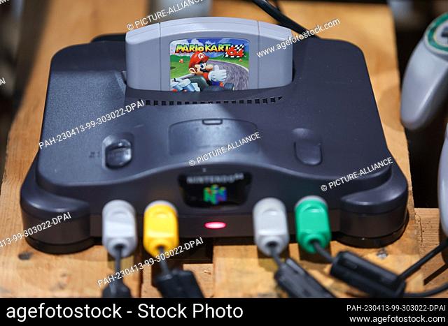 13 April 2023, Saxony, Leipzig: A Nintendo 64 game console with the game ""Mario Kart"" lies in a retro area of the gaming festival ""CAGGTUS"" at the Leipzig...