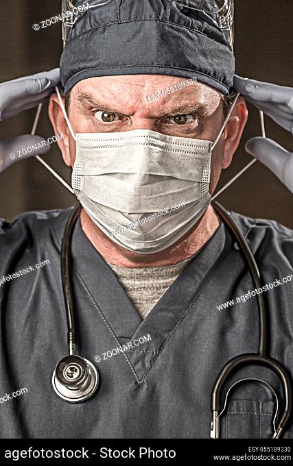 Male Doctor or Nurse Wearing Scrubs, Protective Face Mask and Goggles