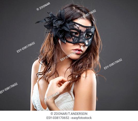 Young woman in lingerie wearing a mask