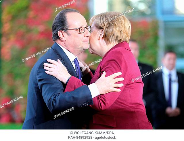 German chancellor Angela Merkel greets the president of France, Francois Hollande for the Ukraine summit in front of the German Federal Chancellery in Berlin