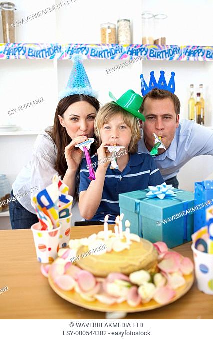 Joyful parents celebrating their son's birthday in the kitchen