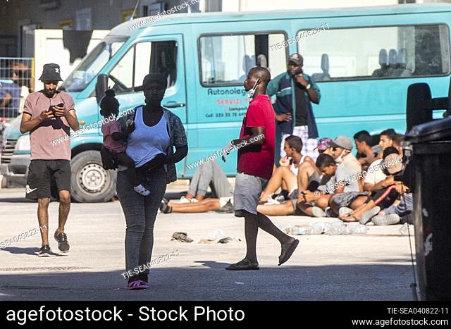 Migrants wait to board an Italian Coast Guard ship in the Sicilian Island of Lampedusa, Italy, . The migrants reception center on the island