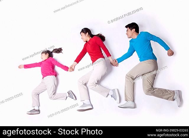 Family holding hands and imitating running, studio shot