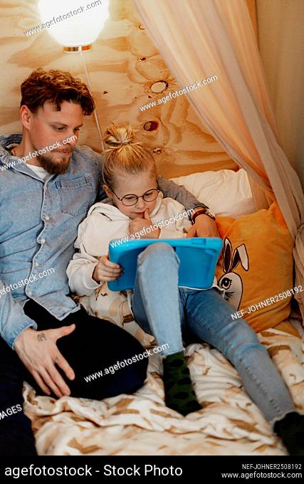 Father with daughter using digital tablet