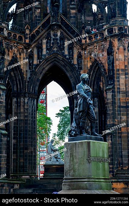Edinburgh, United Kingdom - July 27, 2018: Explorer David Livingstone statue and Scott Monument dedicated to author Sir Walter Scott in the background