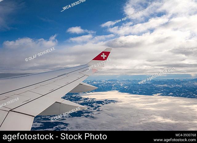Switzerland, Europe - Flying on a Swiss International Air Lines Airbus A220 from Zurich to Berlin with aerial view from the airplane of wing and the snow...