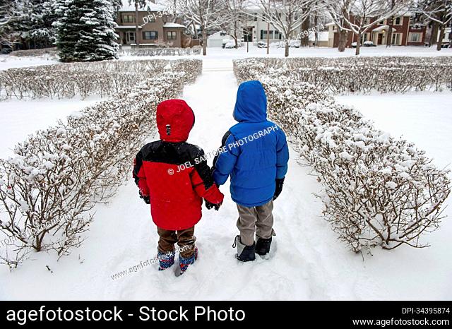 Two young boys prepare to play in the snow; Lincoln, Nebraska, United States of America