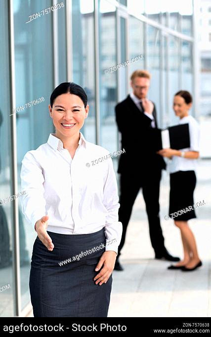 Businesswoman offering a handshake. Pretty asian woman in white shirt going to cooperate with your company or enterprise