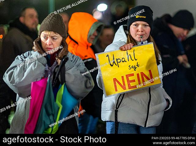 03 February 2023, Mecklenburg-Western Pomerania, Grevesmühlen: A young woman holds a sign reading ""Upahl says no"" before the start of a citizens' meeting held...
