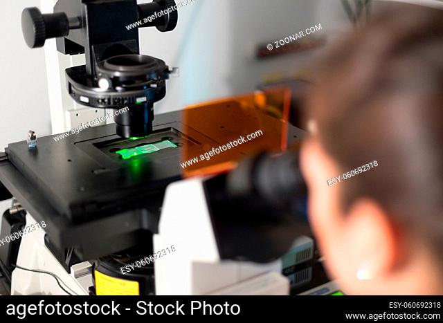 Life science female researcher microscoping in scientific genetic laboratory. Healthcare and biotechnology