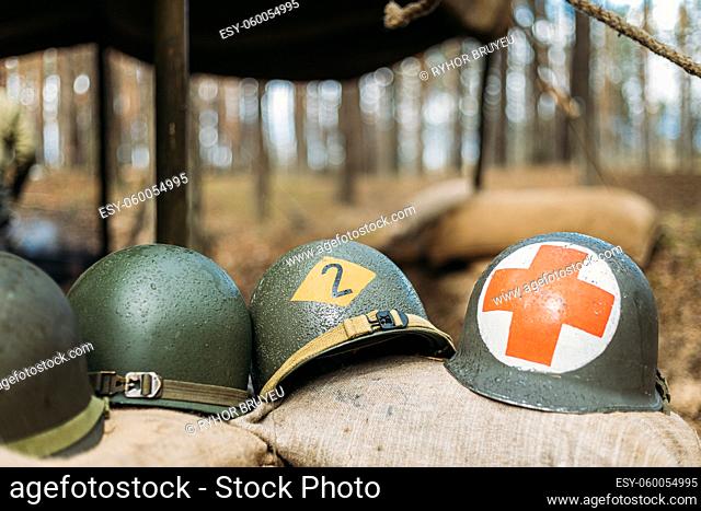 Metal Helmets Of United States Army Infantry Soldier At World War II. Helmets Near Camping Tent In Forest Camp