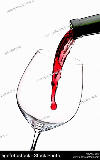 Pouring Red Wine from a Bottle into a Glass