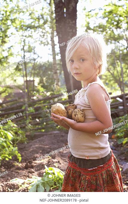 Girl holding potatoes