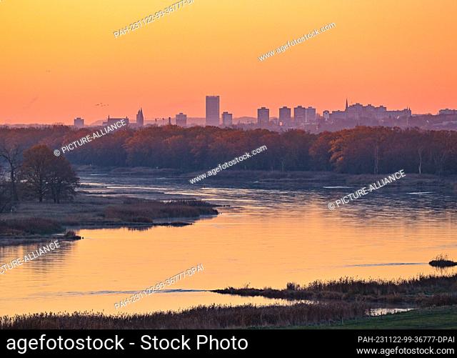 22 November 2023, Brandenburg, Lebus: Sunrise over the Oder, the German-Polish border river, with a view of the city of Frankfurt (Oder) in the background