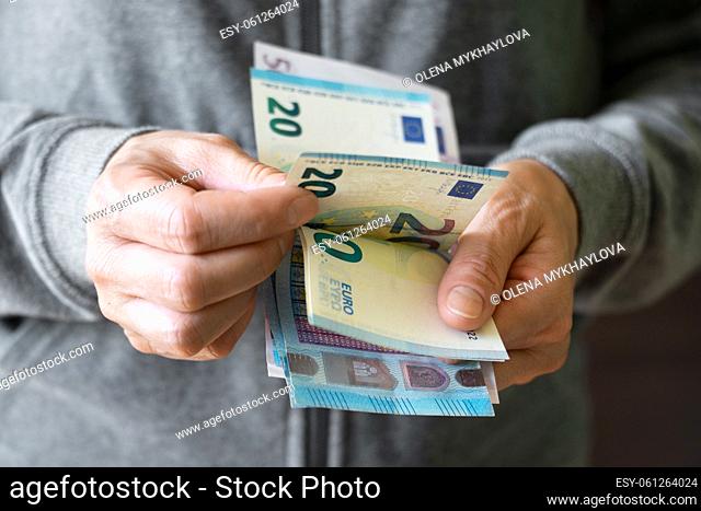 White female count euro bills in her hands
