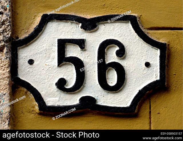 Vintage grunge square metal rusty plate of number of street address with number. Close up, brand