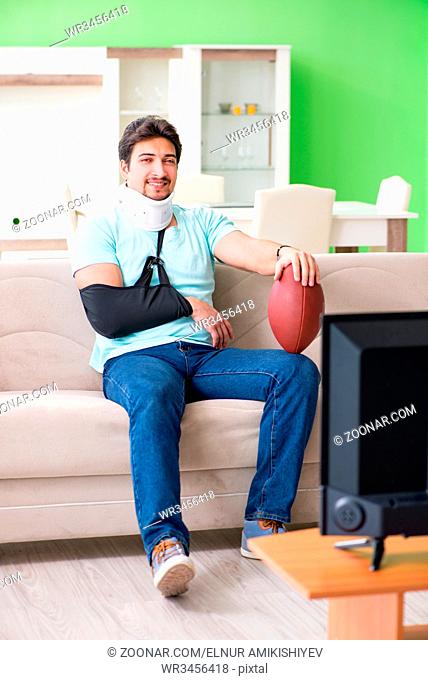 Man with neck and arm injury watching american football on tv