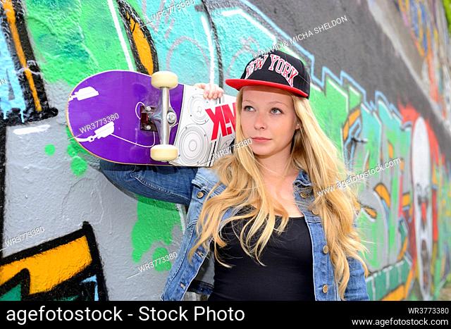 Young woman at a graffiti wall, Nuremberg, Bavaria, Germany, Europe