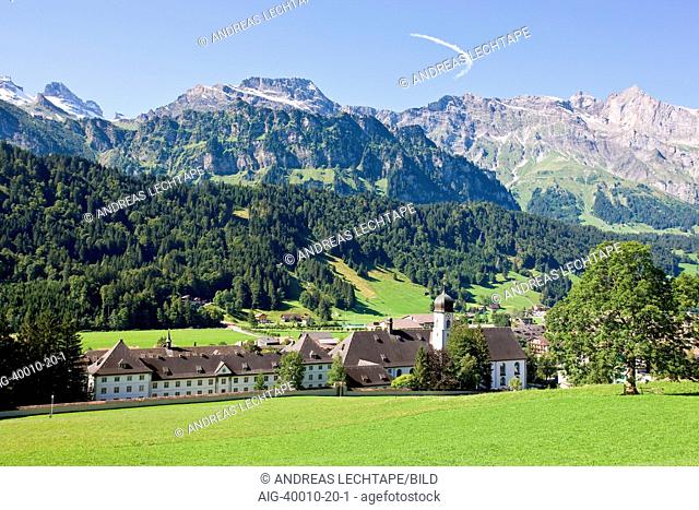 North side of Engelberg Abbey nestled against mountains, a Benedictine monastery in Engelberg, Switzerland